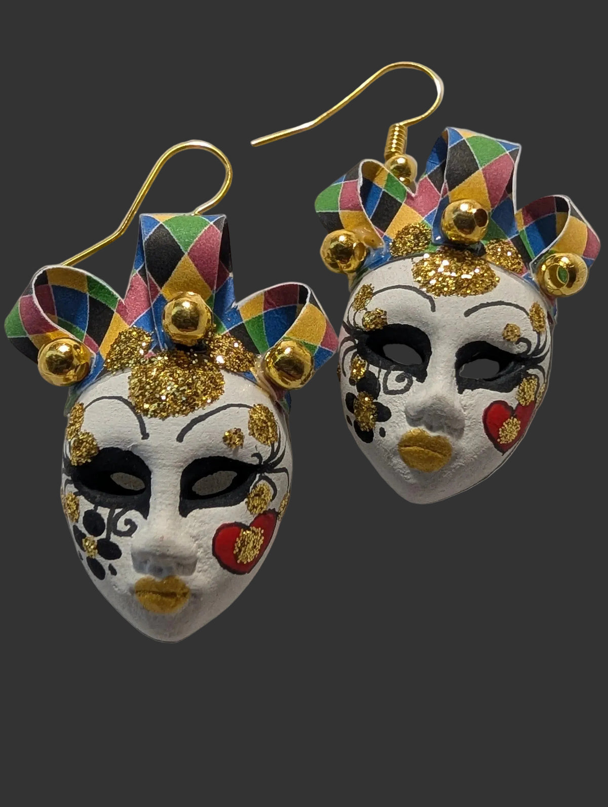 Pair of colorful mask earrings on a textured white background
